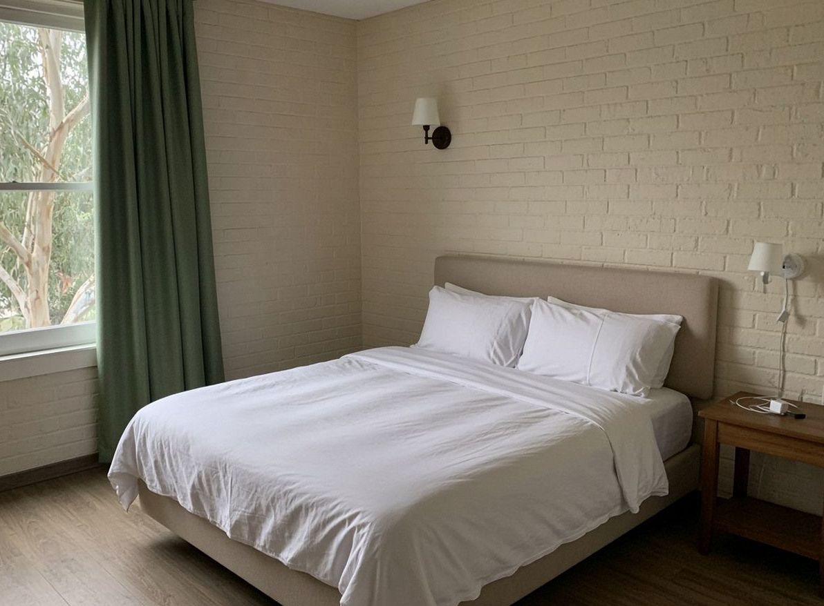 Hotel bedroom, cream brick wall, white linen, eucalypt-green curtain